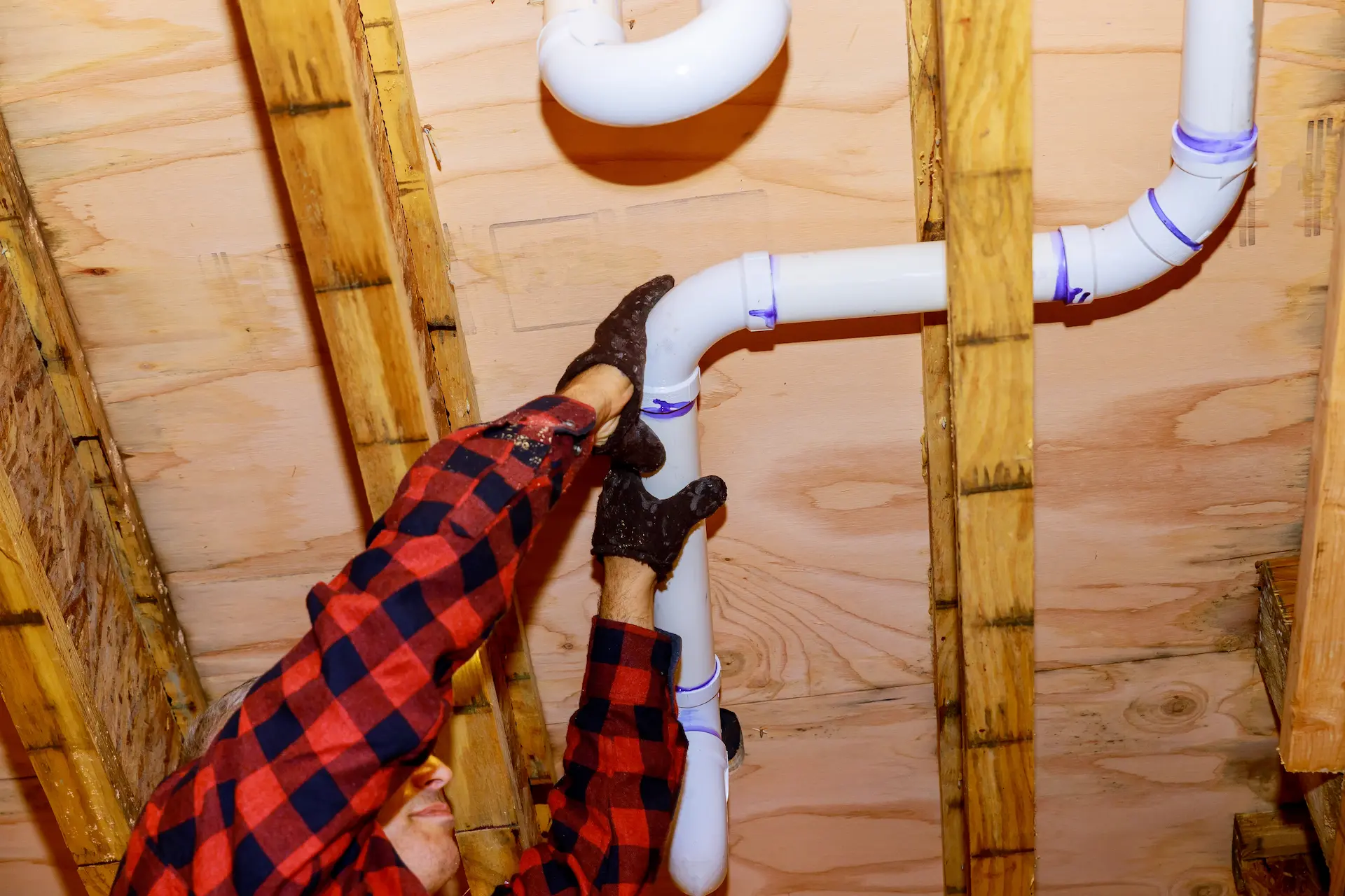 man in flannel hanging pipes